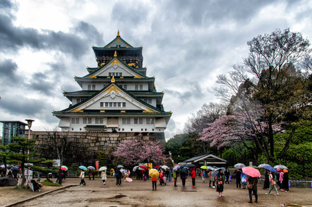 Osaka, Japan - April 01, 2016: Crowds of tourists visiting Osaka Castle Park beneath the iconic five storey keep in the heart of Japan's vibrant second city.のeditorial素材