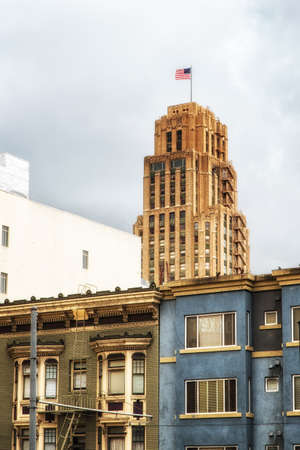 skyscraper with american flag, with typical San Francisco Architecture in the foregroundの写真素材
