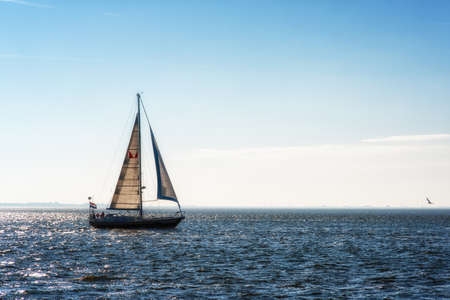 Sailing boat on the open sea at the sunset