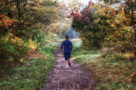 woman trail runner running in forest.の写真素材