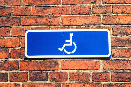 A Blue Wheelchair Sign agains a blue skyの写真素材