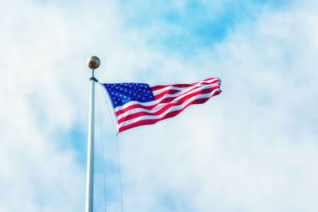 American flag waving against blue skyの写真素材