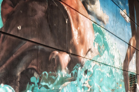 Glasgow, UK - July 07, 2017: A mural showing three swimmers painted on one of the supports of the...