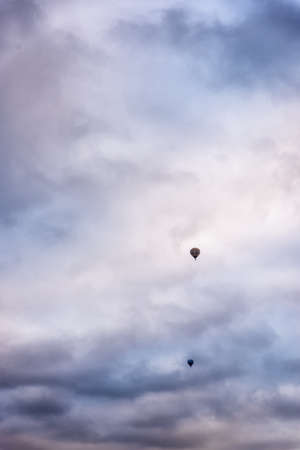Silhouette of hot air balloon going up in a beautiful sky at sunrise.の写真素材