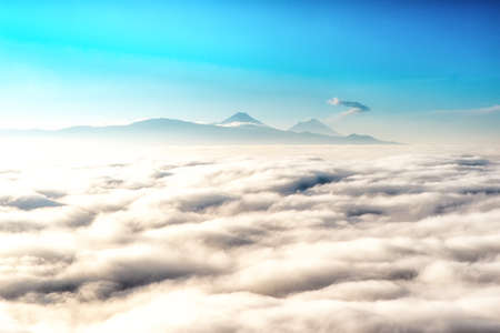 View above the clouds with in the distance the popocatepetl volcano, Mexico.の写真素材
