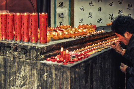 Chengdu, China - 05 February 2019: A man  praying for blessings with incense sticks at the Zhaojue...