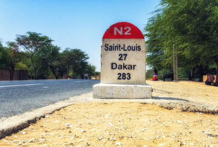 Dakar road sign against clear blue sky.