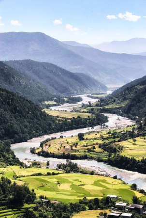 The glacially fed Paro Chhu (Paro river) flows past the city of Paro, Bhutan providing mineral rich water used to irrigate the infamous pink rice of the region.の写真素材