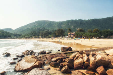 Shek O, Hong Kong - People sunbathing at Shek O Beach, a sandy public beach at Shek O village, a popular weekend and holiday destination located on Hong Kong southern coast.の写真素材