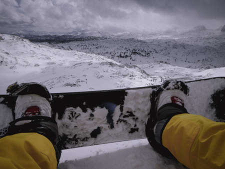Legs of snowboarder on snowy resort. Winter vacationの写真素材