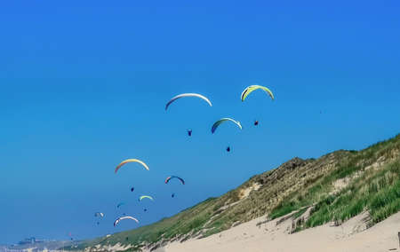 Para glider flying above the dunes en beach having fun and a great adventure.の写真素材