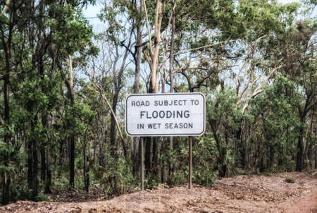 Sign warning of water covering road. Kakadu National Park, Northern Territory, Australiaの写真素材