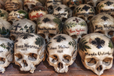 View of hundreds of painted skulls and bones inside the famous charnel house at the mountain village Hallstatt in the Salzkammergut region, Austriaのeditorial素材