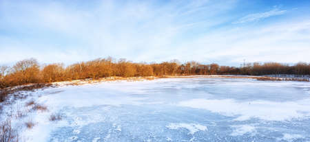 Winter landscape with snow and a frozen lake in the Netherlandsの写真素材