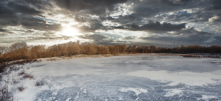 Natural winter forest landscape With frozen lake at sunsetの写真素材