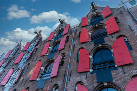Facade of an old Dutch house with red shutters in Amsterdam.の写真素材