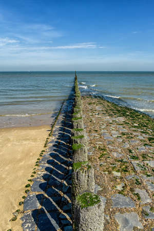 Beach with wooden weave breakers in landscape.の写真素材