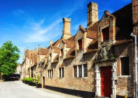 Beautiful urban scene and cityscape of medieval architecture. View of the Almshouses (The Pelicaen) old facade  in the ancient European city Brugge.の写真素材