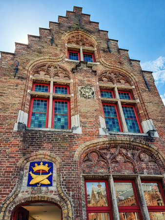 Traditional colorful Belgian facades of houses with weaponshield of Bruges, Belgiumのeditorial素材