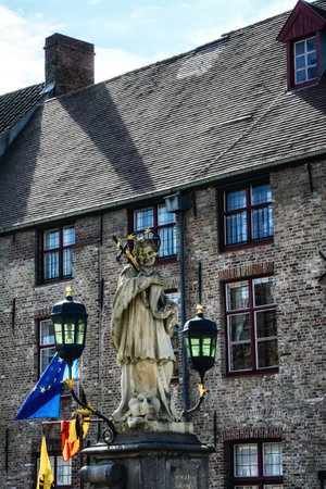 Statue of Saint Joannes Nepomucenus on Wollestraat bridge over Dijver canal in the old town of Bruges (Brugge), Belgiumのeditorial素材