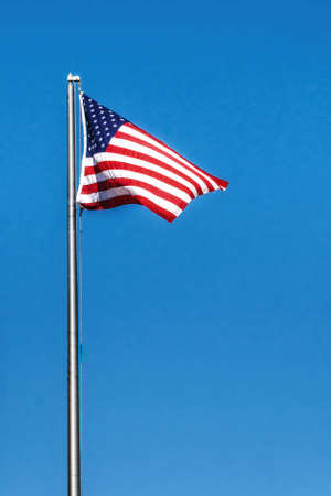 American Flag Waving In Wind Against a Deep Blue Sky.の写真素材