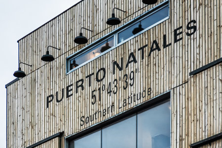 Building with a sign saying Puerto Natales 51degrees 43 minutes 39 seconds Southern Latitude. Puerto Natales, Chileのeditorial素材