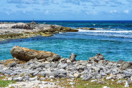 Waves breaking at the rough shoreline of the east coast of the tropical island of Bonaire.の写真素材