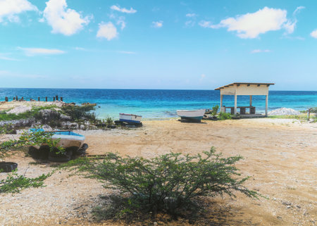 Boat next to a shed on the sandy beach of the caribbean island in bonaire. Netherlands Antilles.の写真素材