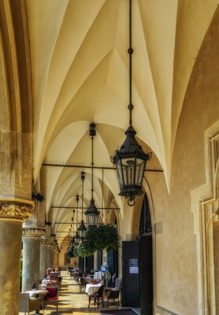 Krakow, Poland - 12 August 2022: Cafe tables vaulted arcade of the Cloth Hall in the Main Squareの写真素材