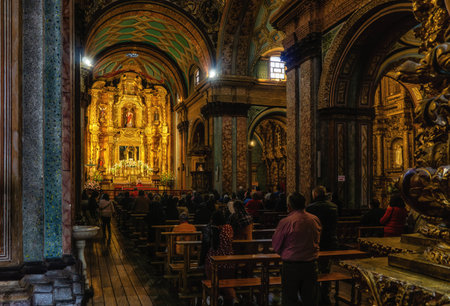 Quito, Ecuador - 24 November 2022: People praying  in the church of El Sagrario in the historic center of Quitoのeditorial素材