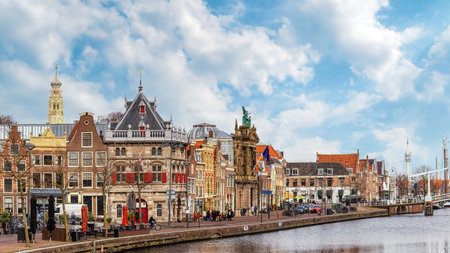 Spaarne river with row of old houses and weigh house in the city of Haarlem, Holland, Netherlandsの写真素材