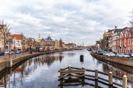Spaarne river with row of old houses and weigh house in the city of Haarlem, Holland, Netherlandsの写真素材