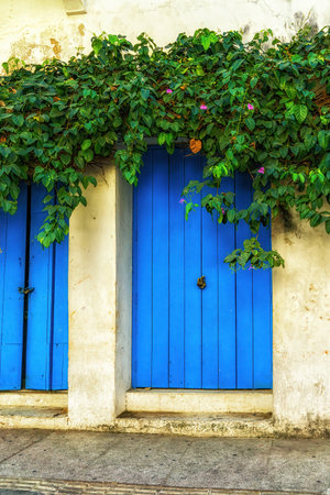 Beautiful facade of a house with blue door in the center of the city, Cartagena, Colombiaの写真素材