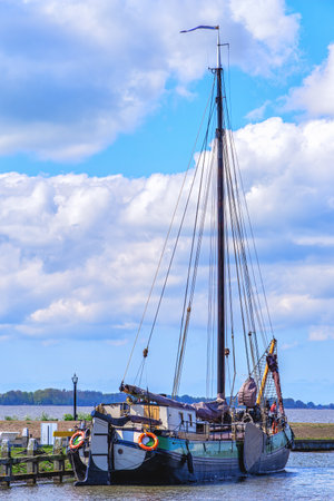 A traditional fishing boat is docked on the jetty in Marken village in Holland, Netherlandsの写真素材