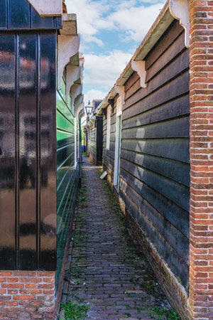 View down the alley behind the traditional wooden houses of the town Marken, The Netherlandsの写真素材