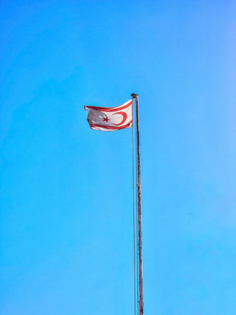 Northern Cyprus flag floating in the wind with a blue sky background