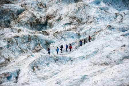 Hikers and travelers walking on ice in Fox Glacier, New Zealand. Breathtaking guided glacier walk onto the world-famous Fox Glacier.の写真素材