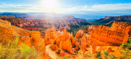 Panoramic view of amazing hoodoos sandstone formations in scenic Bryce Canyon National Park in beautiful golden morning light at sunrise with dramatic sky and blue sky, Utah, USAの写真素材