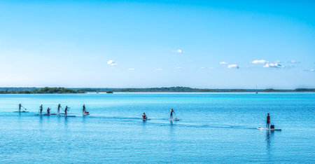 Bacalar, Mexico - February 27, 2024: Paddle boarding in beautiful Bacalar lagoon in Quintana Roo, Mexico. with calm watersの写真素材