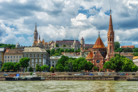 A scenic view of Budapest with historic buildings from the Danube River under a blue skyの写真素材