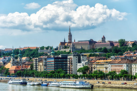 Scenic riverbank promenade with historic buildings and a calm river in the background. A blend of leisure and architectural beauty, Budapest, Hungaryの写真素材