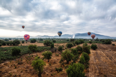 Colorful hot air balloons in rural farm fieldの写真素材