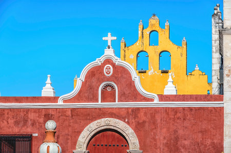 Detail of a small colonial red Mexican church in Campeche, Mexico, over blue sky.の写真素材
