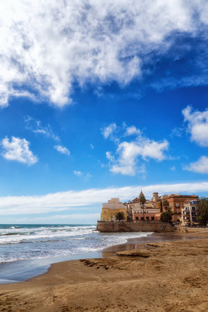 Beach and seafront of Sitges, with the imposing Church of St. Bartholomew and St. Thecla, dating back to the 17th centuryの写真素材