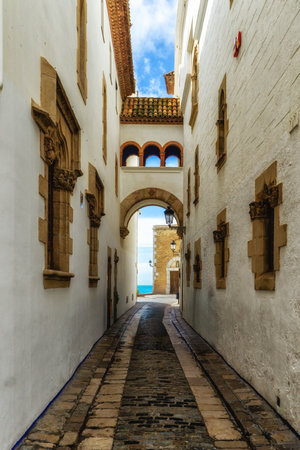 View of the a small street and alleys of Sitges, medieval Spanish town in the coast of Catalonia. Spanish architecture and tourismの写真素材