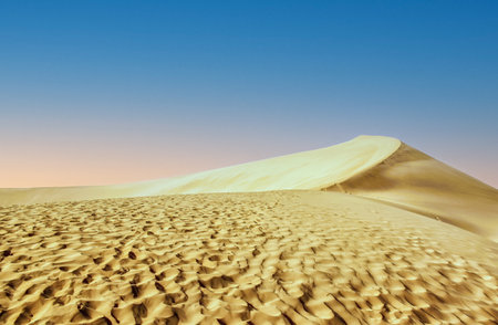 The giant singing Sand Dunes (Ming Sha Shan) in Dunhuang, China, are the sand dunes that, when the wind blows, give out a singing or drumming sound. They are part of the Kumtag Desert.の写真素材