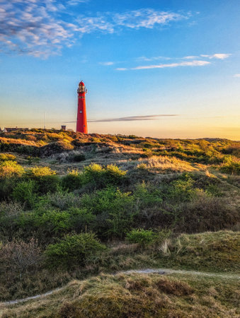 Schiermonnikoog  view in the dunes with the lighthouse during sunset at the wadden island during a beautiful spring day. Schiermonnikoog is part of the Frisian Wadden Islands and is known for its beautiful natural scenery, including sandy beaches, rolling dunes, and lush wetlands.の写真素材