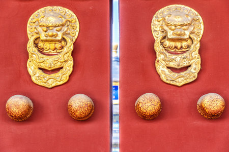 ancient red doors with gilded studs and lion head door knockers in Temple of Heaven.の写真素材
