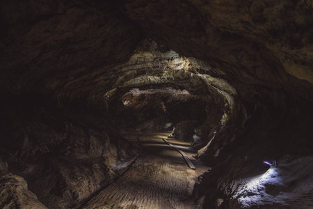 Underground rock formations in Remouchamps caves, cracked, rough and uneven walls due to erosion and...