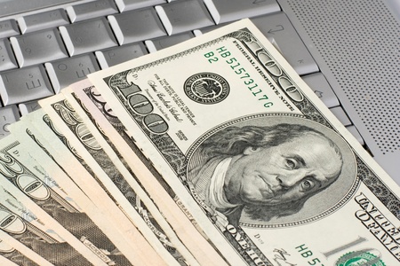 dollars on a laptopの写真素材